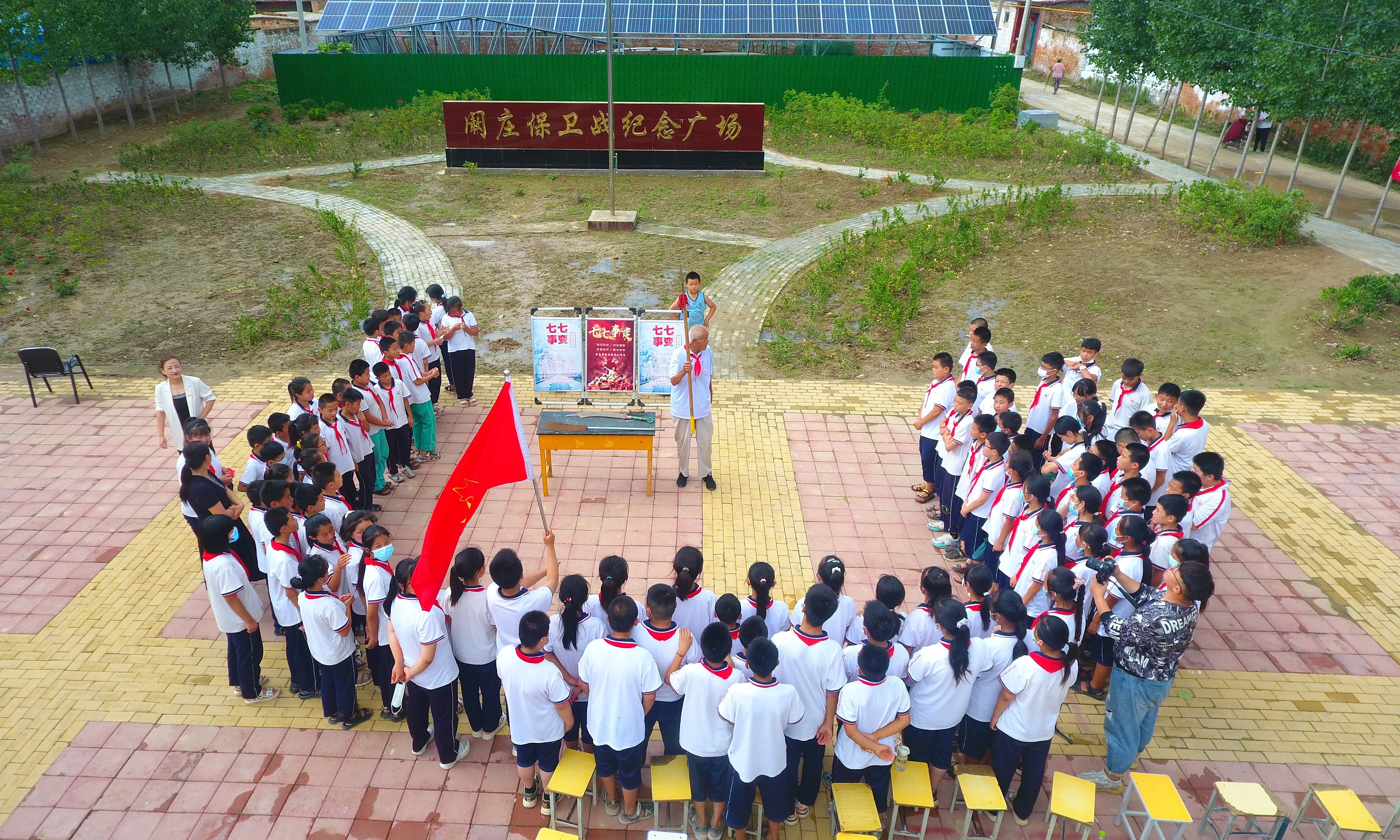 2022年7月6日，山東省聊城市，在茌平區(qū)菜屯鎮(zhèn)闞莊村的闞莊保衛(wèi)戰(zhàn)紀(jì)念廣場，闞莊保衛(wèi)戰(zhàn)親歷者王光木老人，為小學(xué)生們講述抗戰(zhàn)故事，展示大刀、長矛。