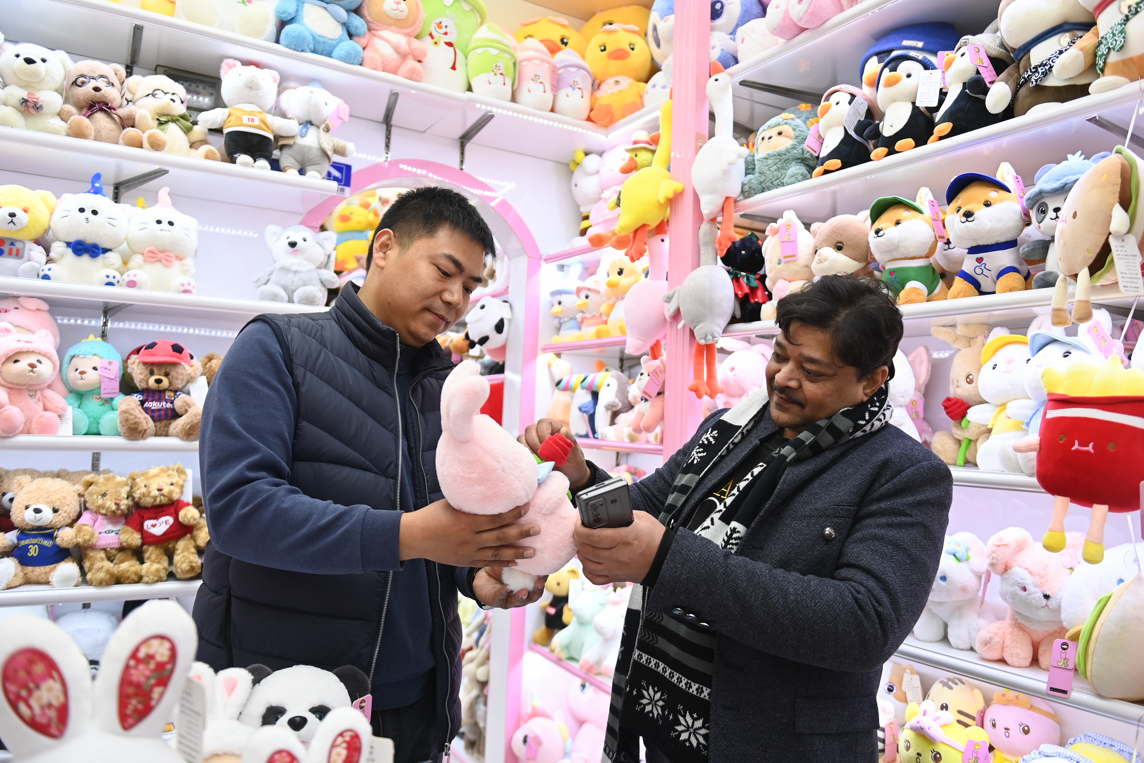 2023年2月2日，來(lái)自印度的客商（右）在義烏國(guó)際商貿(mào)城的一家玩具店鋪內(nèi)選購(gòu)。